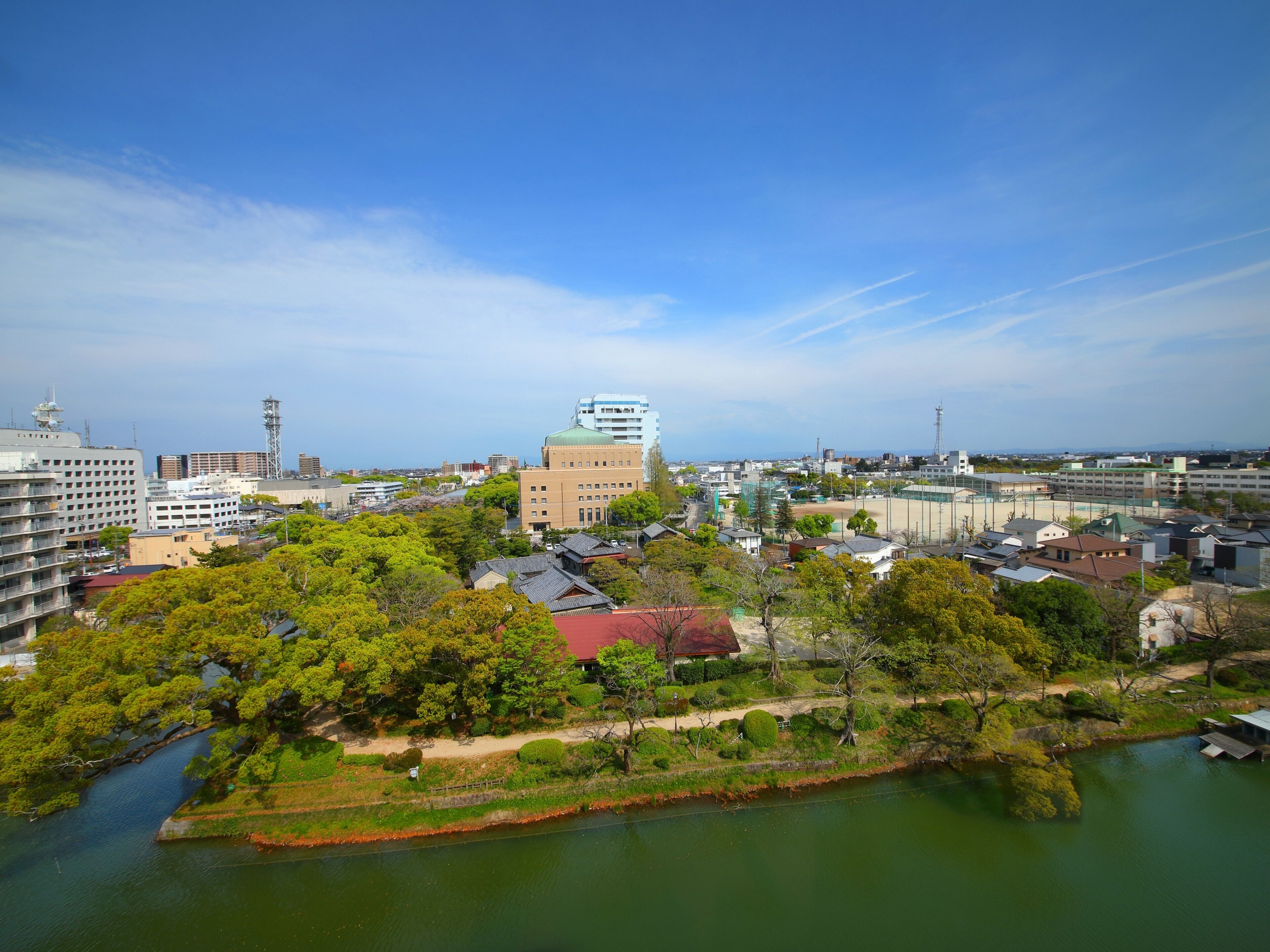 A cityscape with a mix of modern and traditional architecture, a river, and a clear sky.