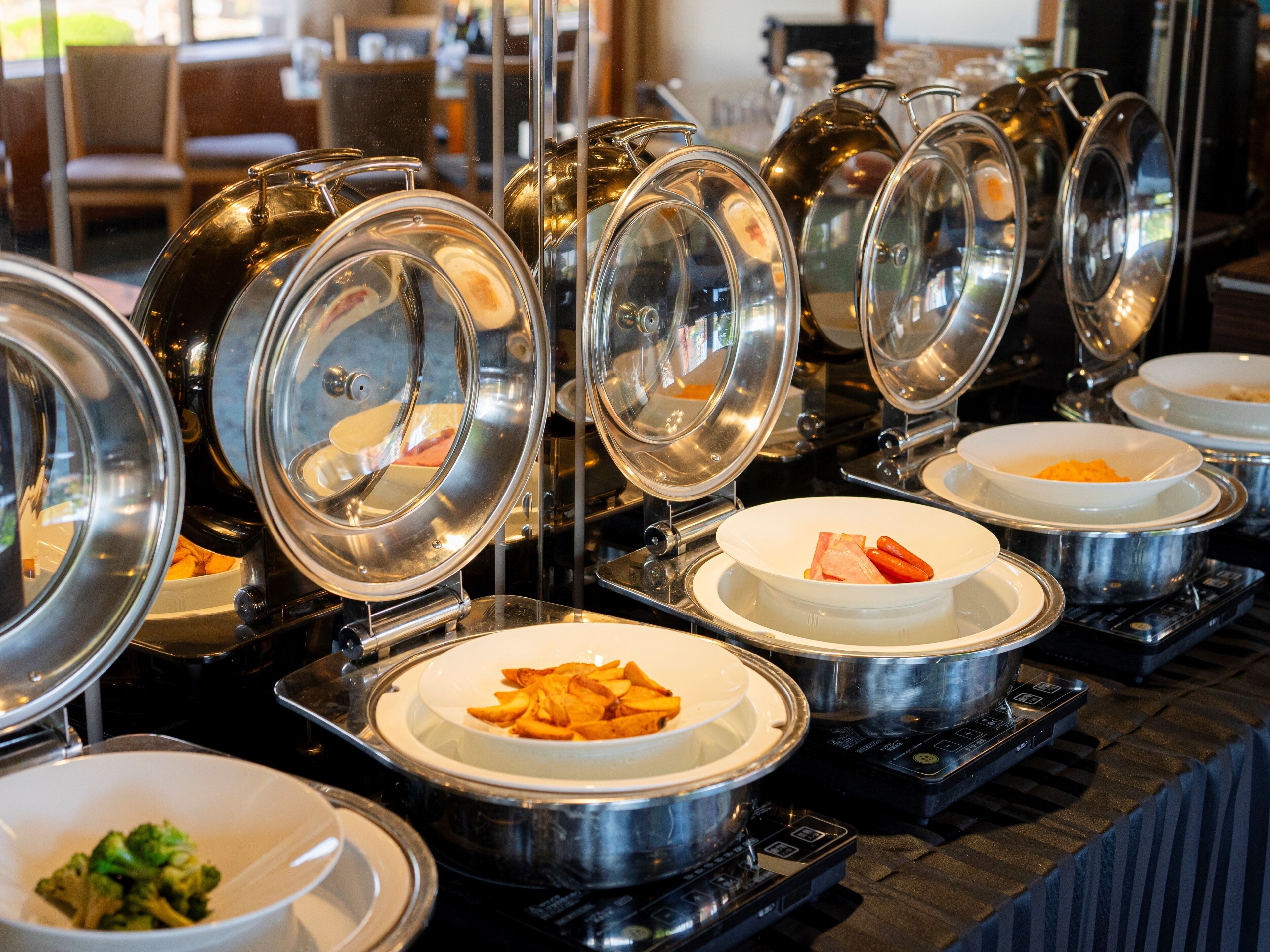Buffet-style food stations with covered dishes.