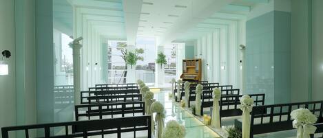 A modern church interior with pews, a wooden organ, and a glass altar.