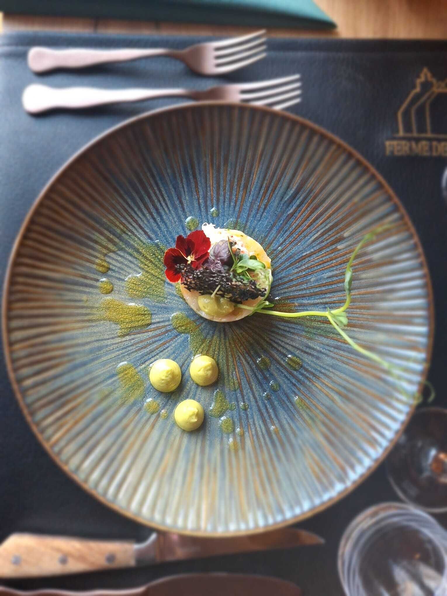 A plate of food with a blue rim, a fork, and a knife on a table.