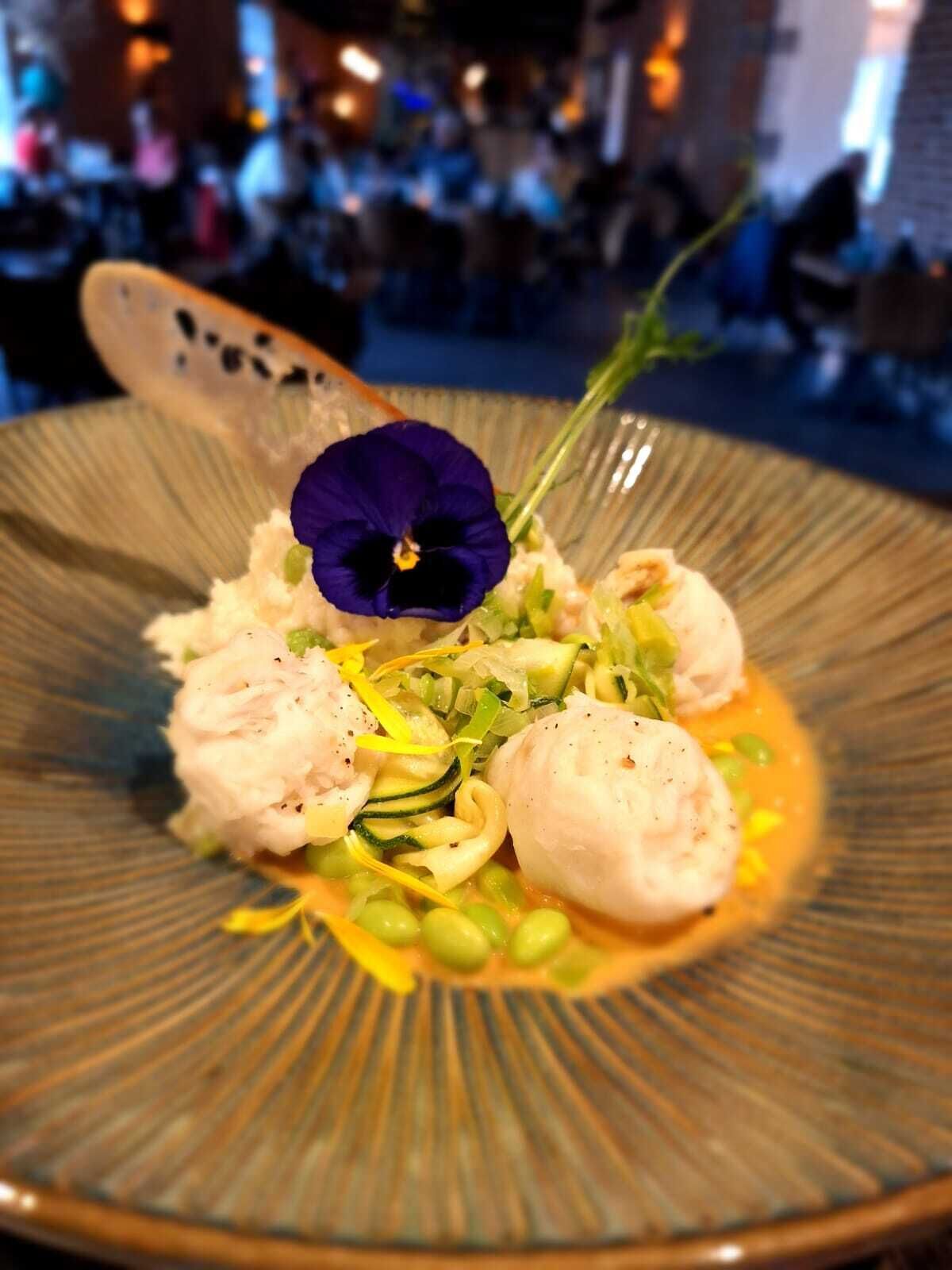 Ein Teller Essen mit Blumenverzierung.