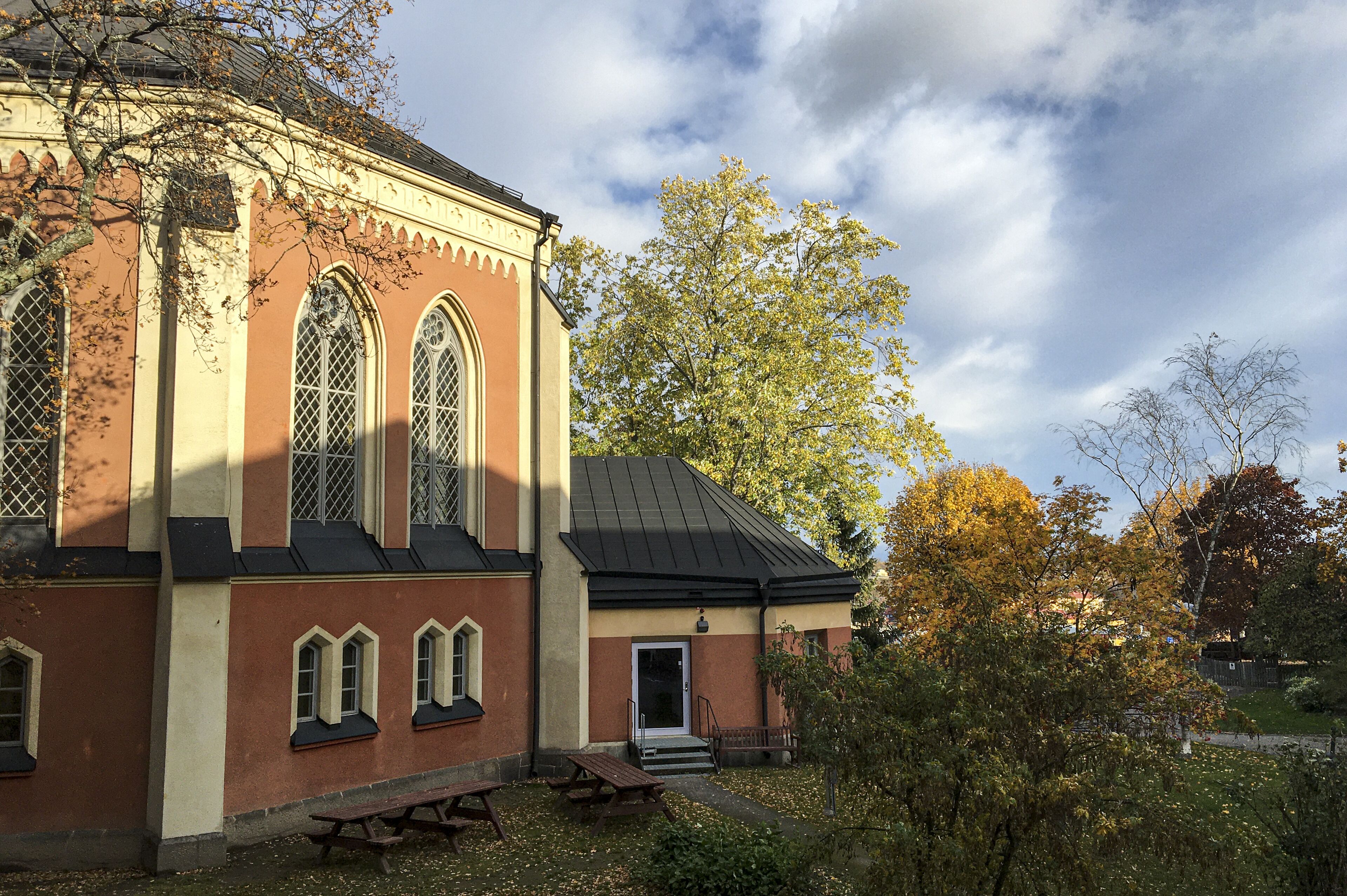 Une église dotée de fenêtres en arc et d’un clocher.