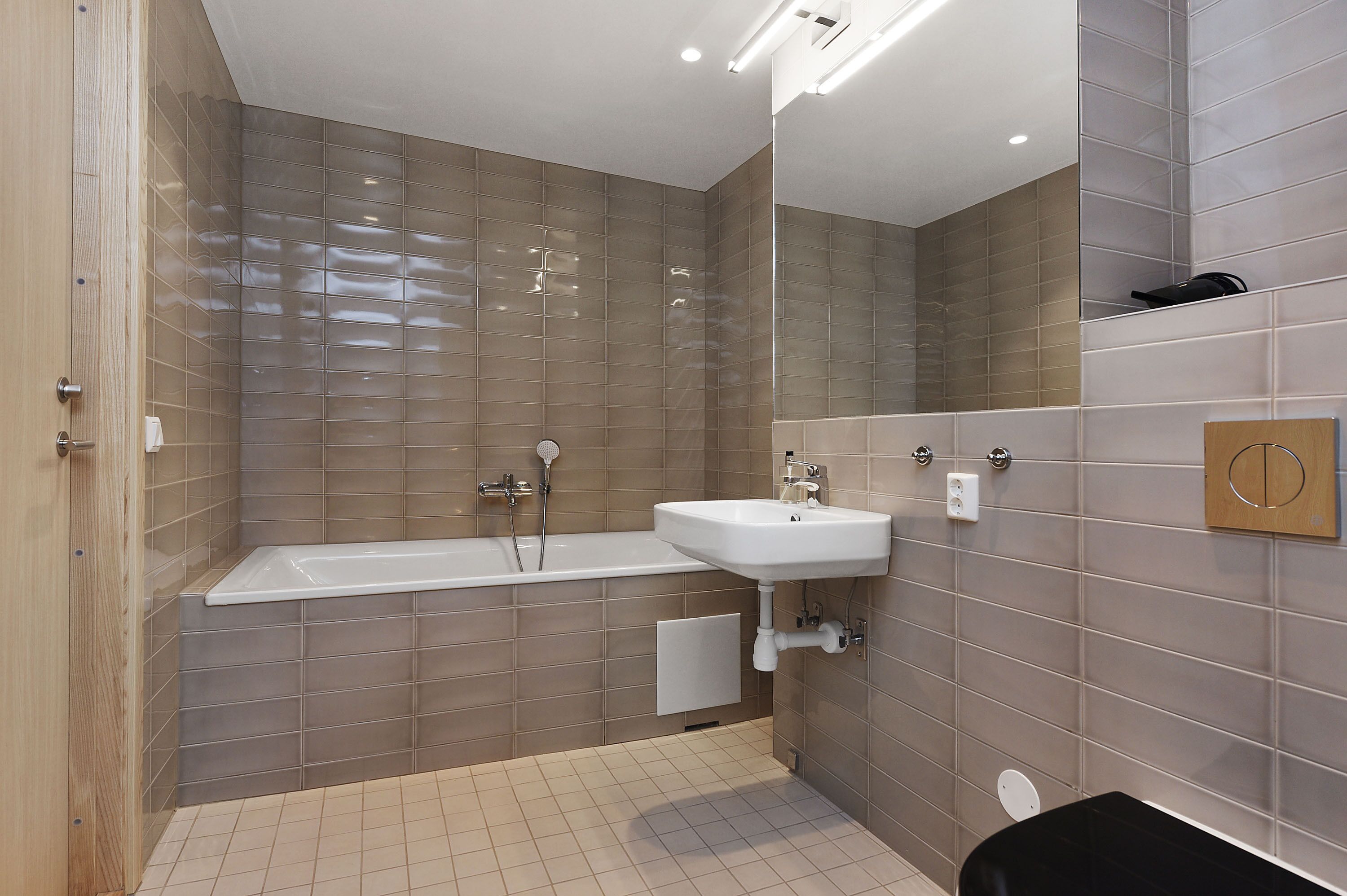 Un baño moderno con una bañera, un lavamanos y un espejo.
