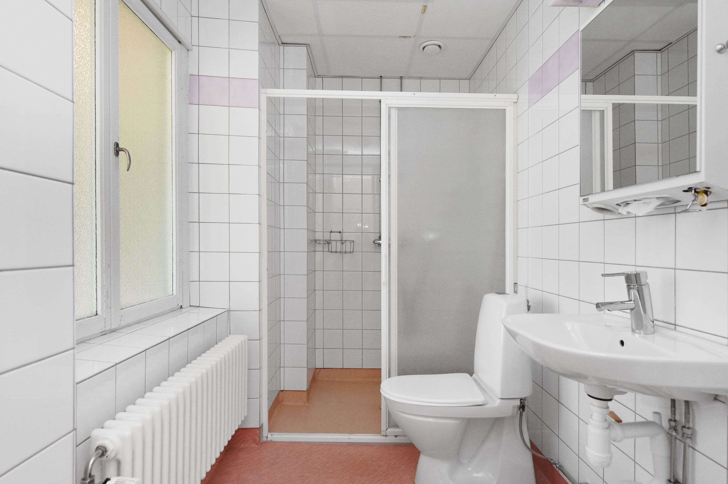 Een moderne badkamer met toilet, wastafel en douche.