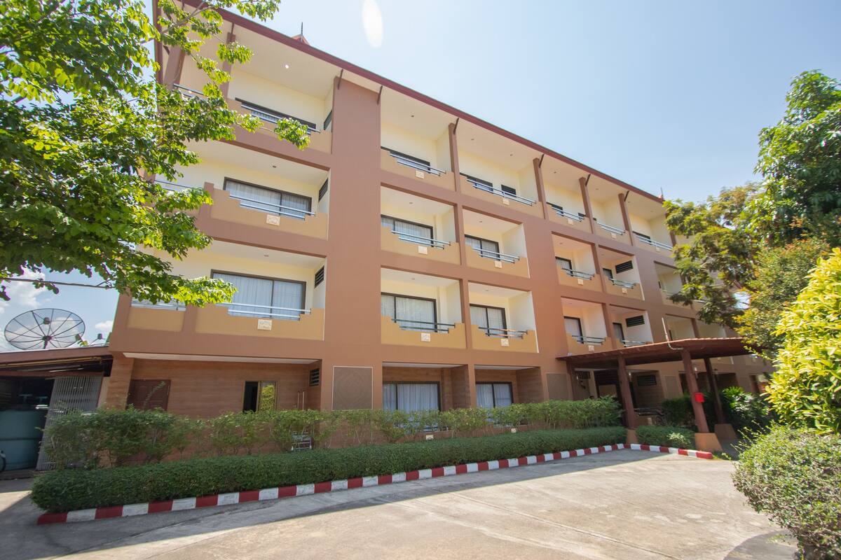Un hôtel à plusieurs étages, doté d’une façade beige, de balcons et d’une entrée couverte.