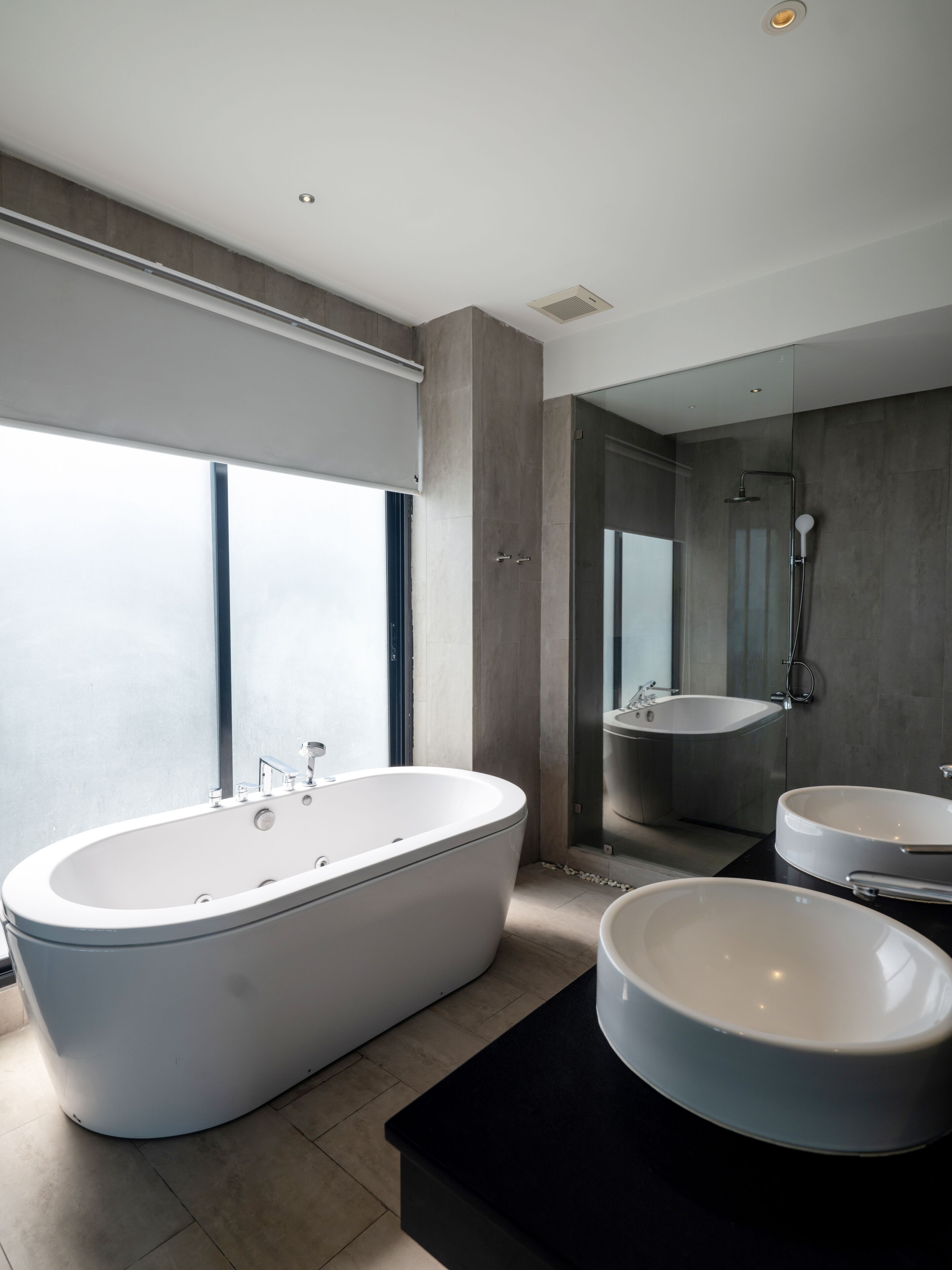 Un baño moderno con una bañera independiente, un lavamanos independiente y una ducha integrada.