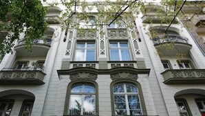 Un edificio de varios pisos con detalles arquitectónicos ornamentales, como ventanas en arco y molduras decorativas.
