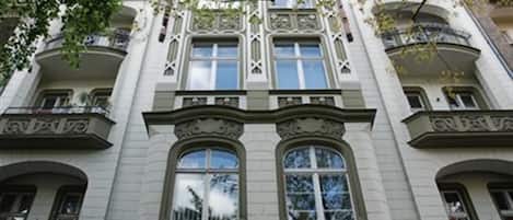Un edificio de varios pisos con detalles arquitectónicos ornamentales, como ventanas en arco y molduras decorativas.