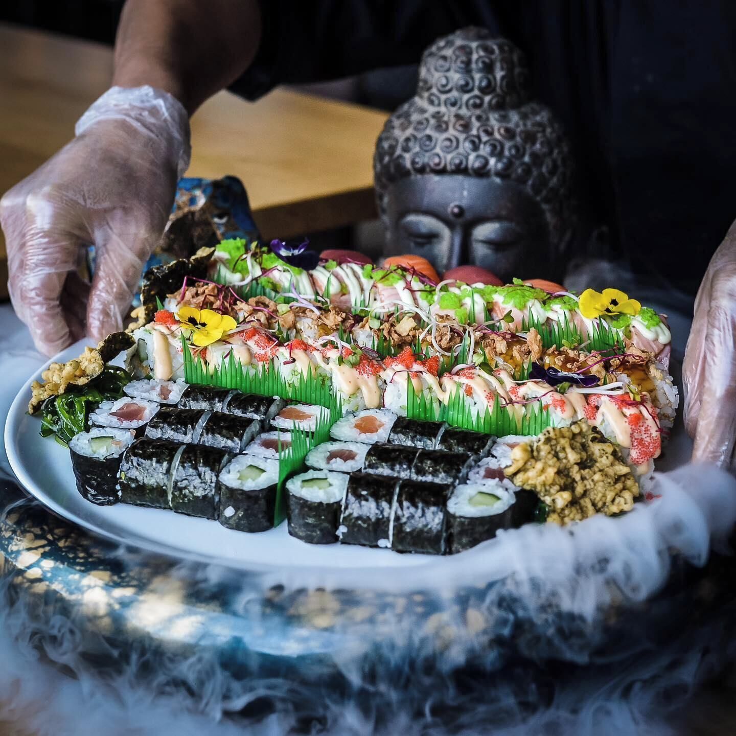 Un plato de sushi con diversos ingredientes y adornos.