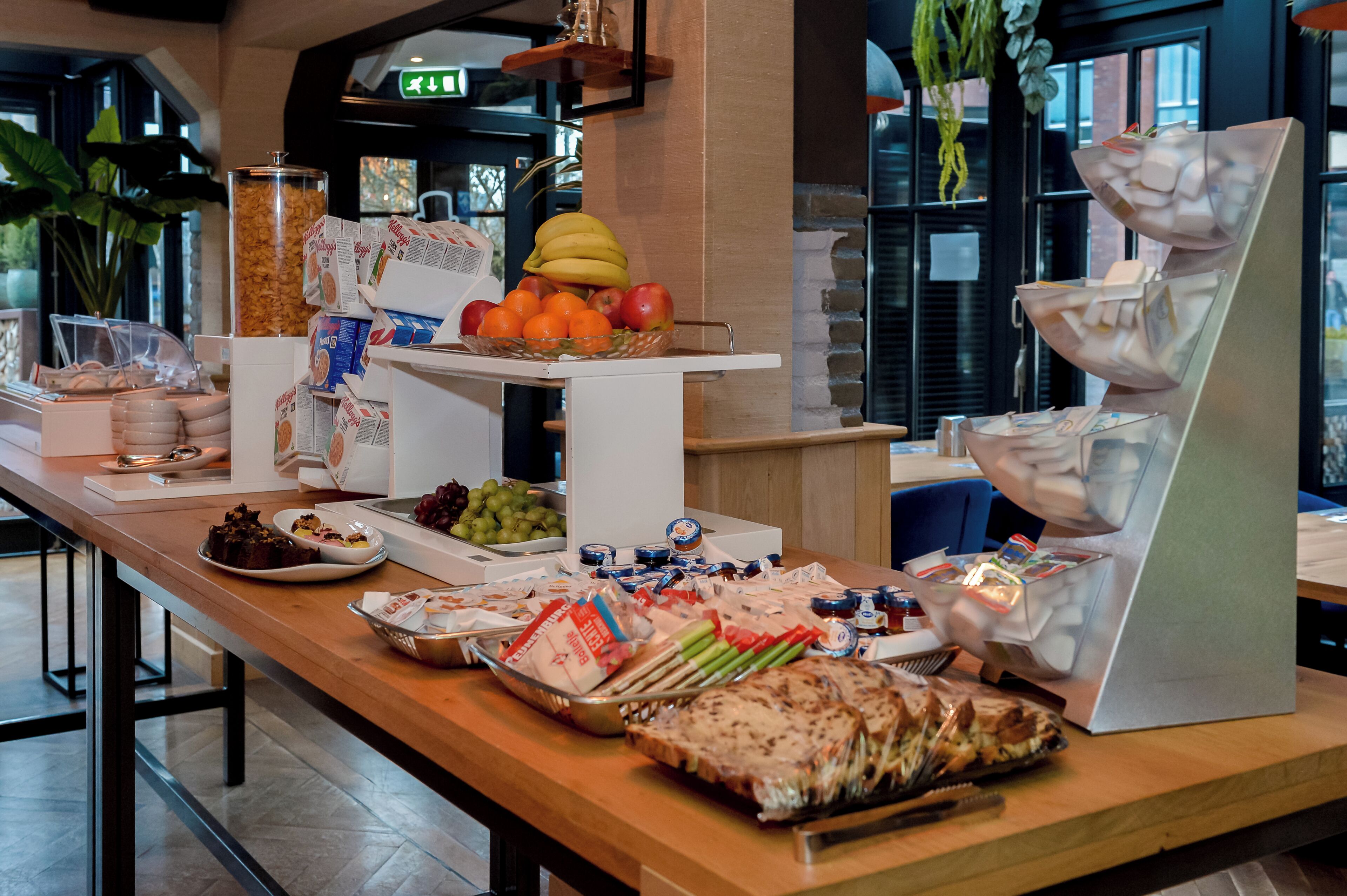 A buffet table with various food items and condiments.