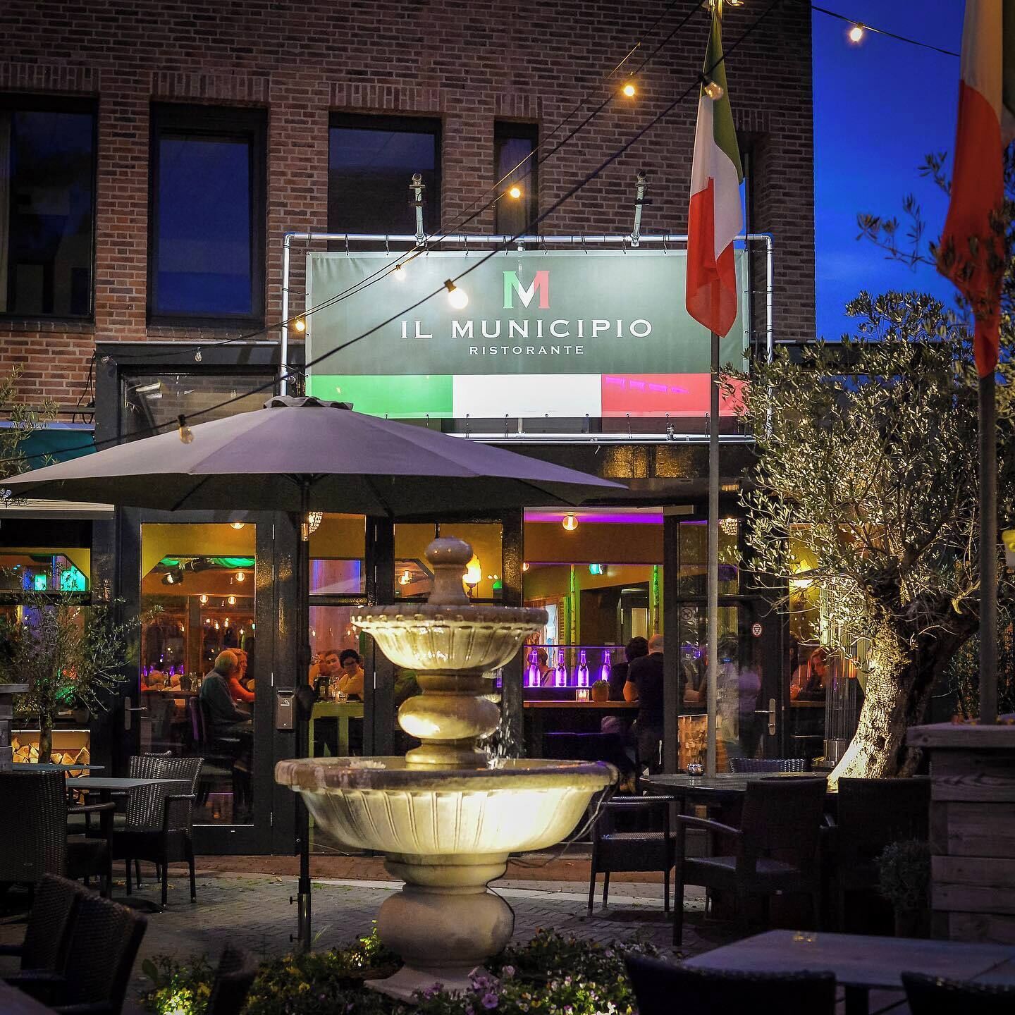 A restaurant named 'Il Municipio' with outdoor seating and a fountain.