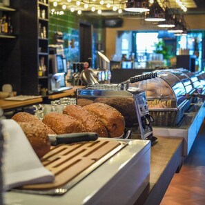 A bakery display with bread and a coffee machine. - Hotel de Schout (Denekamp)