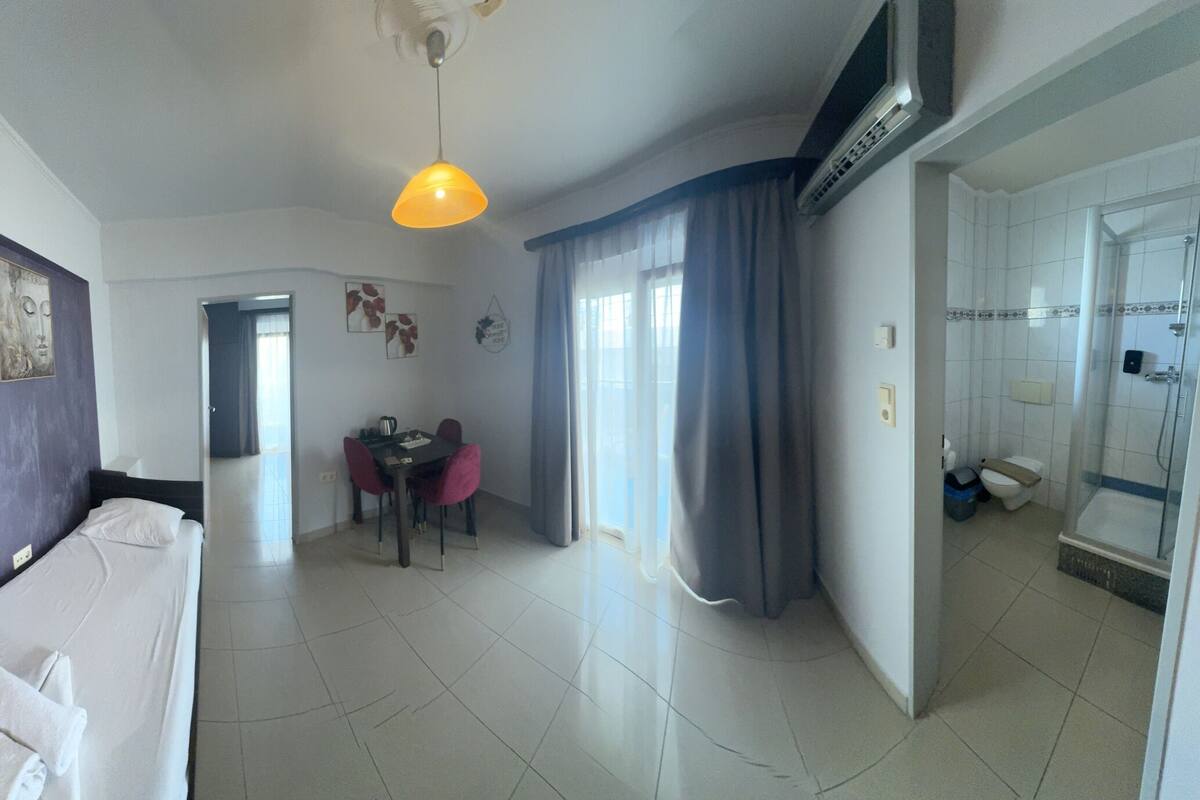 Una habitación de hotel moderna con cocina, comedor y baño.