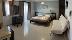 Een hotelkamer met een bed, nachtkastje, bureau, stoel en telefoon.