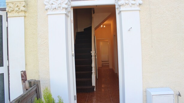 A staircase leading to a door with a white exterior and decorative moldings. - Avenue Inn (London)