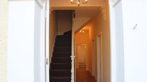 A staircase leading to a second floor with a chandelier above. - Avenue Inn (London)