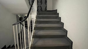 A staircase with a metal railing and patterned wall. - Brunnen Hotel (Essen)