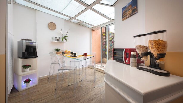 A modern kitchen with a glass dining area, a coffee machine, and a microwave. - Vaticano84 (Rome)
