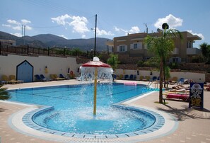 Una piscina al aire libre de temporada, sombrillas