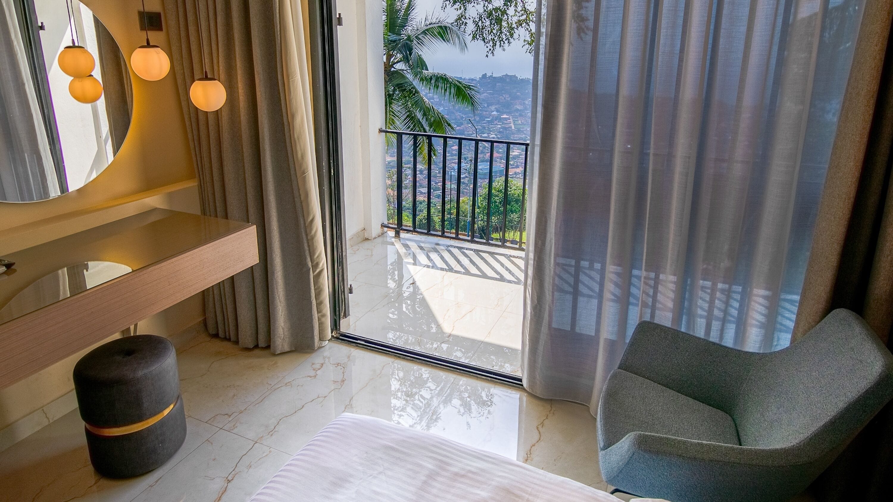 Ein Hotelzimmer mit Bad, Bett, Stuhl und Balkon mit Blick.