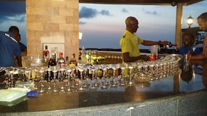A bar area with a stone wall and a view of the sky. - The Country Lodge Hotel (Freetown)