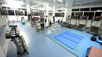 Una sala de gimnàstica amb equipament esportiu, esteves blaus i zones de musculació.