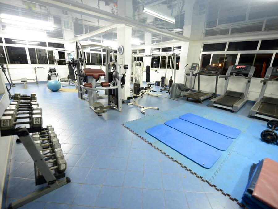 Una sala de gimnàstica amb equipament esportiu, esteves blaus i zones de musculació.