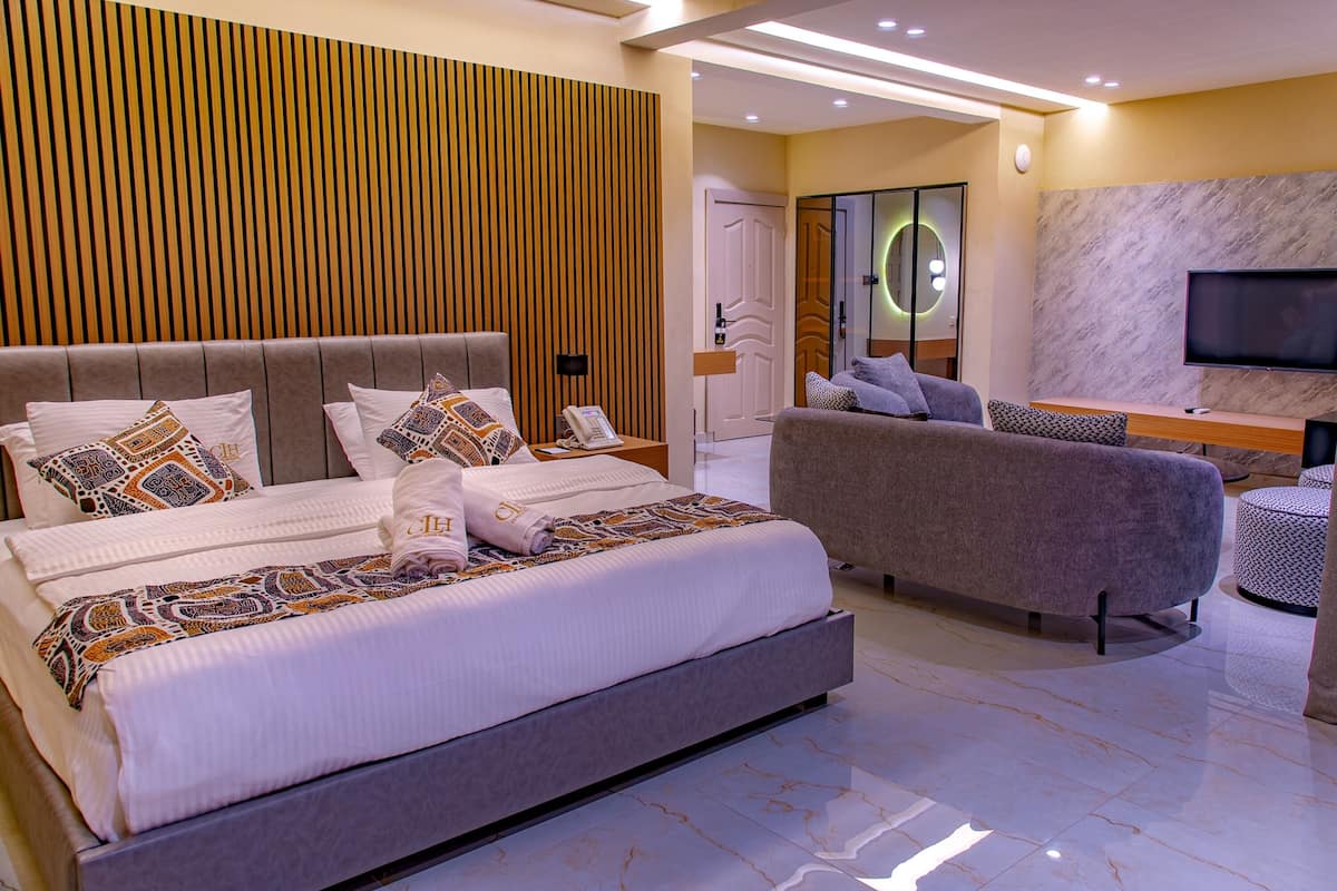 Ein modernes Schlafzimmer mit einem großen Bett, einer Couch und einem Fernseher.