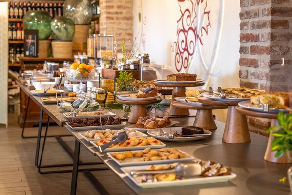 Ein reichhaltiges Buffet mit verschiedenen Speisen und einer Ziegelwand im Hintergrund.
