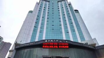 Un edificio de hotel alto con fachada de vidrio moderna y un cartel que indica que es el Fortune Hotel.