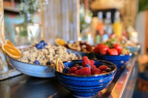 A buffet table with various dishes including fruits and cereals. - Hôtel Le G (Nice)