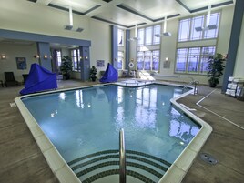 Una piscina techada, sillones reclinables de piscina
