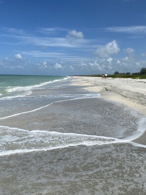 Am Strand, weißer Sandstrand, Sonnenschirme, Strandtücher