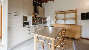 Una cocina moderna con armarios de madera clara, una isla central con asientos y un ventanal sobre la isla.