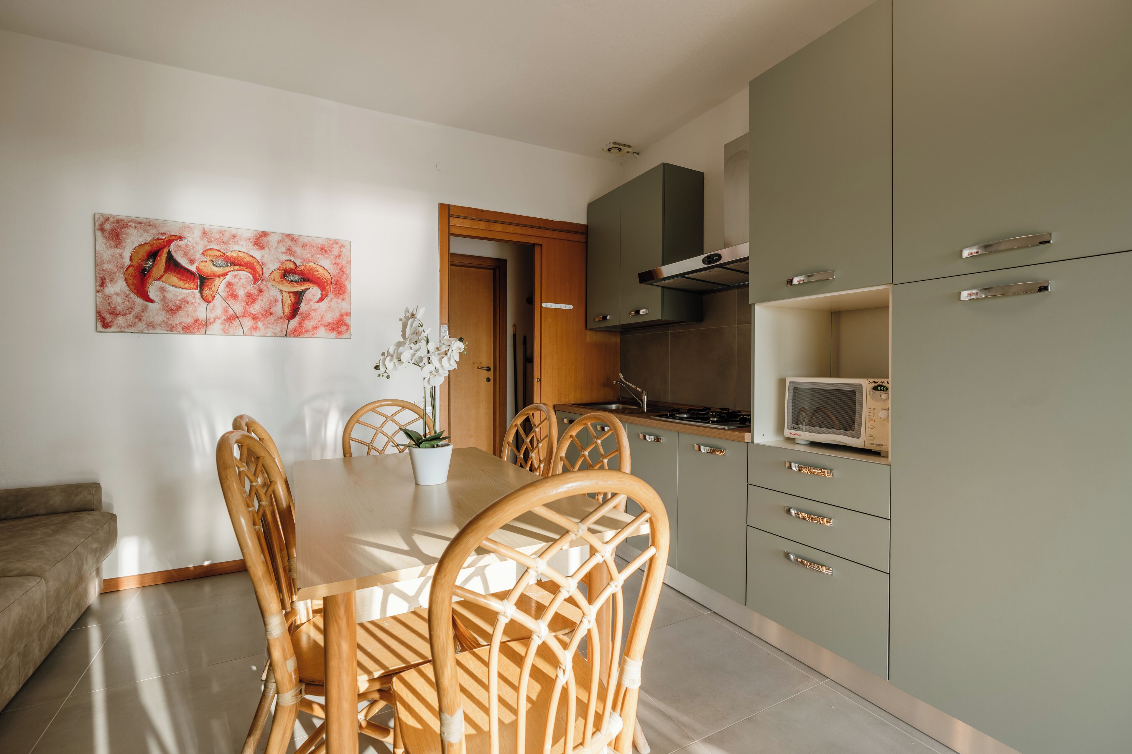Une cuisine moderne avec des chaises en bois, une table à manger et un four à micro-ondes.