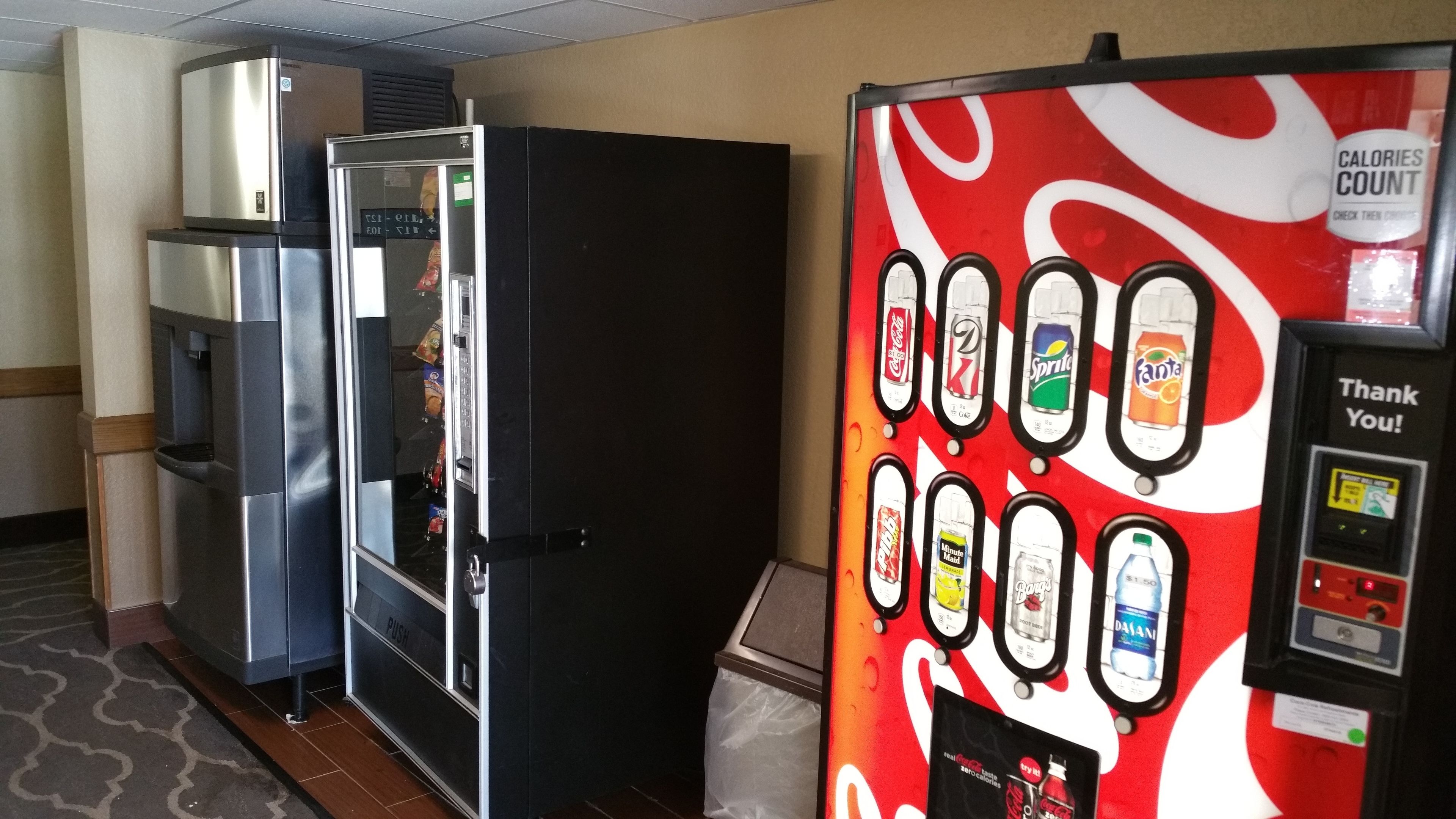 Una máquina expendedora con diversas opciones de bebidas y una máquina de Coca-Cola.