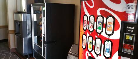 Una máquina expendedora con diversas opciones de bebidas y una máquina de Coca-Cola.