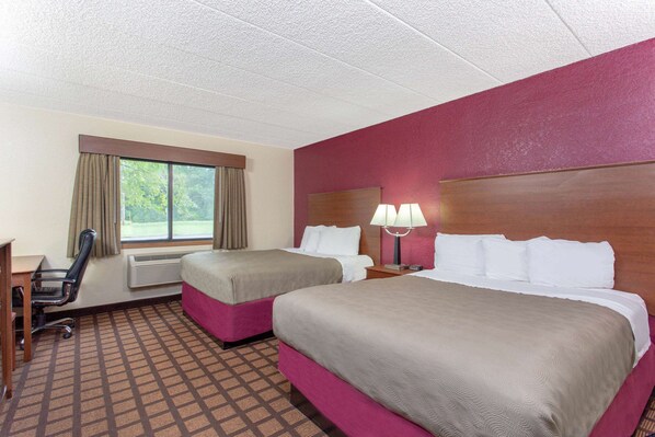 A hotel room with two beds, a desk, a chair, and a window with curtains. - AmericInn by Wyndham Burlington (Burlington)