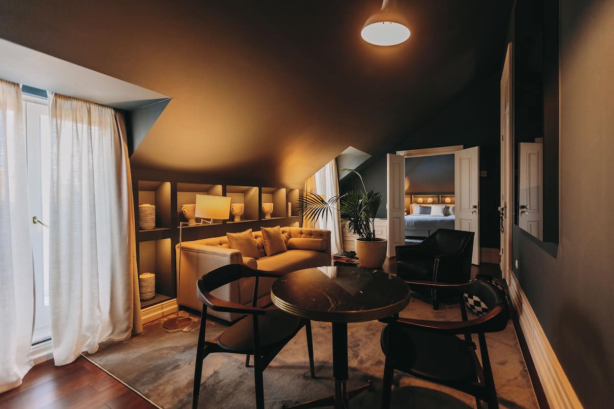 Un salon confortable avec un canapé, une table à manger et des chaises. On y trouve également une plante et une lampe.