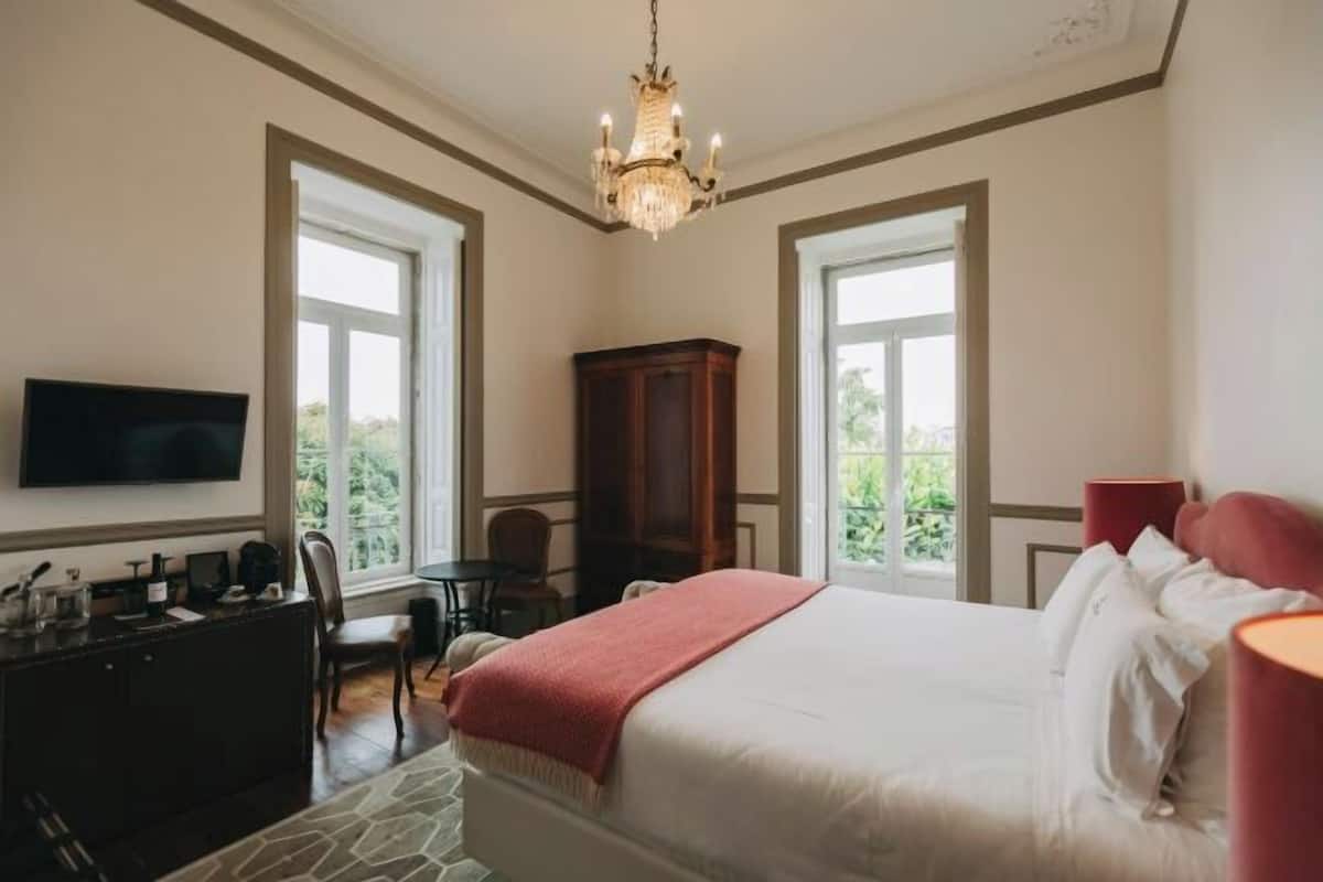 Une chambre à coucher avec un lit, une télévision, un bureau et une chaise.