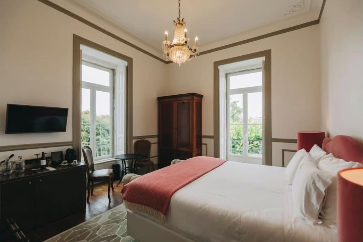 Une chambre à coucher avec un lit, une télévision, un bureau et une chaise.