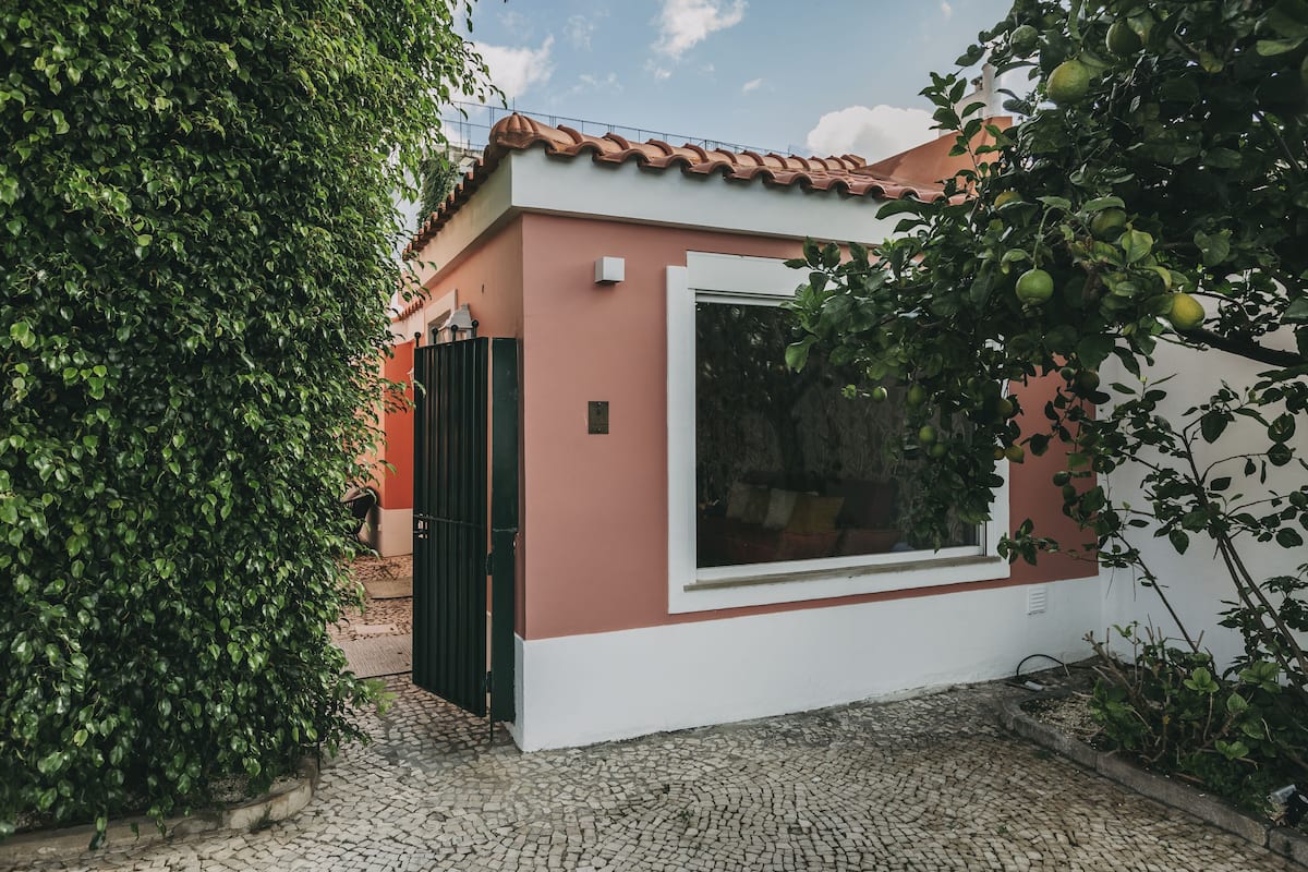 Une maison à l’extérieur rouge et blanc, avec un toit en tuiles et une grande fenêtre.
