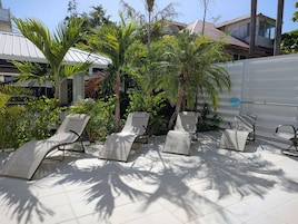 Una piscina al aire libre, sillones reclinables de piscina