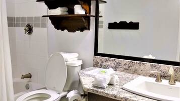 Un baño moderno con inodoro, lavabo y zona de ducha.