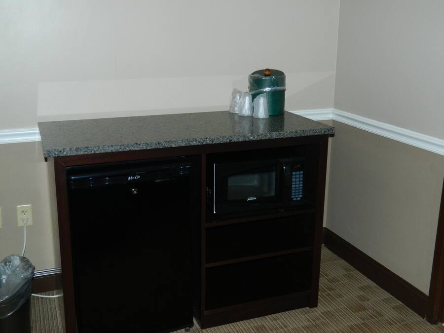 Una kitchenette compacta con lavavajillas, microondas y un refrigerador pequeño.