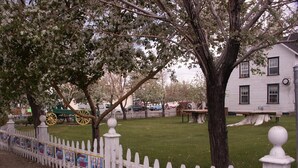 A white picket fence, a grassy area, and a white building with a visible window and door. - Bridgeport Inn (Bridgeport)