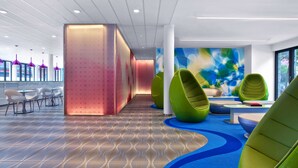 Een modern interieur met een patroon vloer, zithoeken en een kleurrijke abstracte wand.