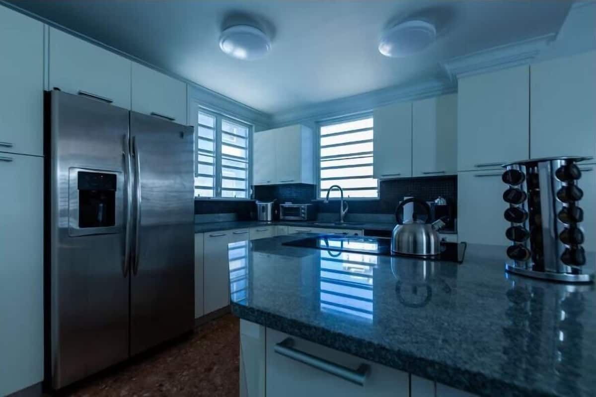 Una cocina moderna con electrodomésticos de acero inoxidable, encimera de granito y un amplio ventanal que proporciona luz natural.