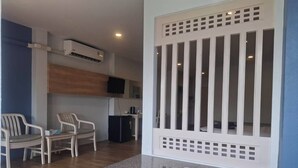 Un bagno con una vasca da bagno bianca, un asciugamano di legno e un piano di lavoro in granito.