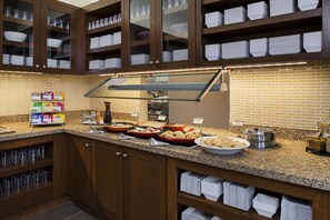 Ein reichhaltiges Buffet mit verschiedenen Speisen und einer Selbstbedienungsstation.